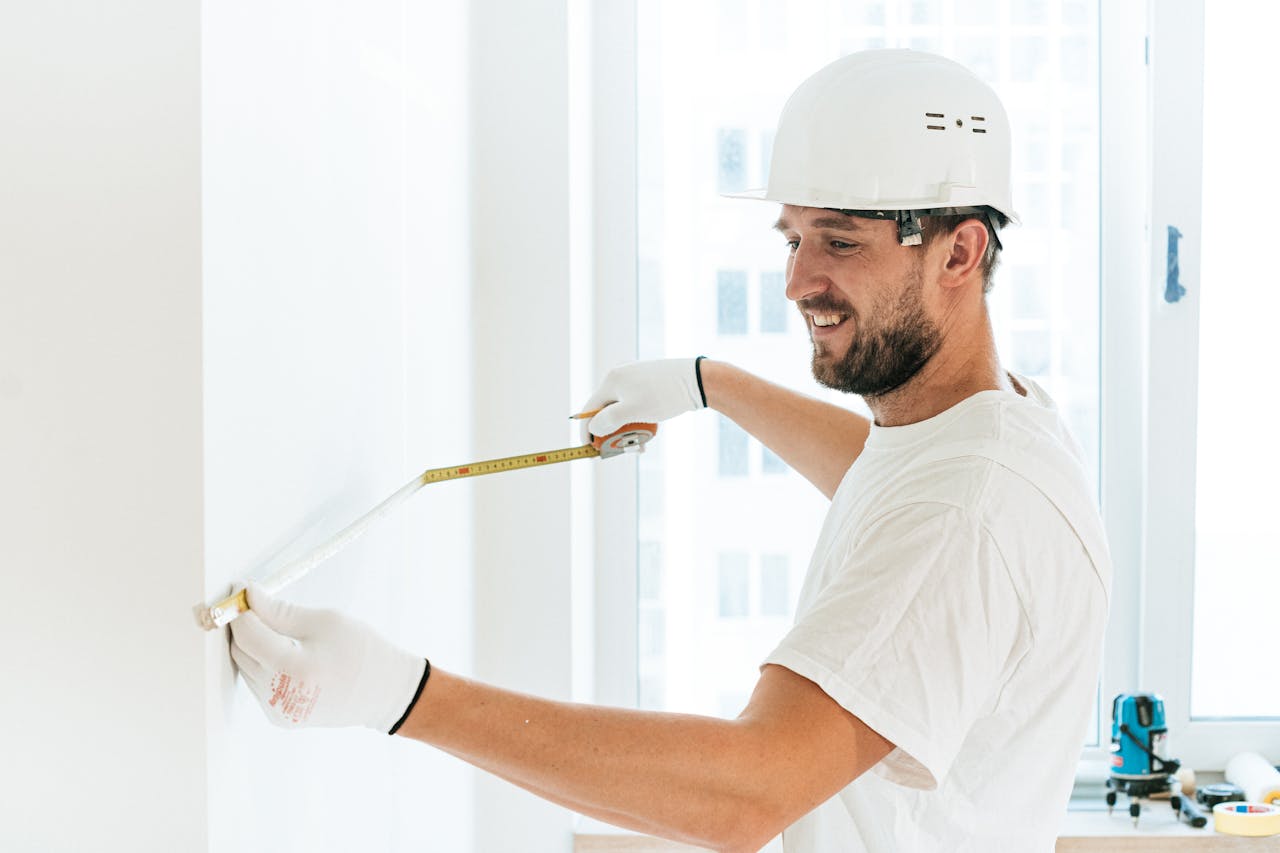 Energetic construction worker using tape measure for indoor renovation.